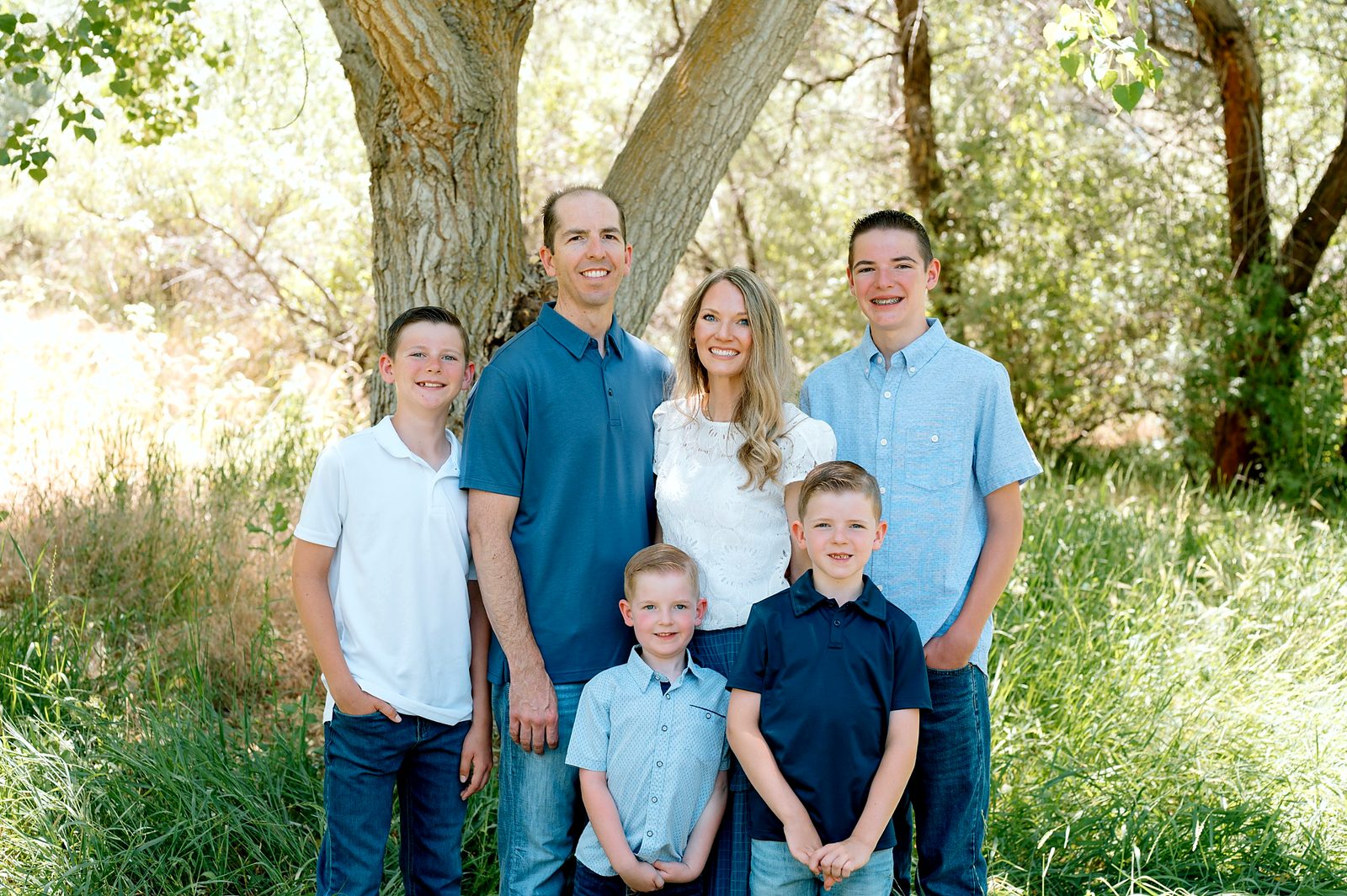 Dr. Keven Freeman with his wife, Amy, and their sons under cottonwood trees